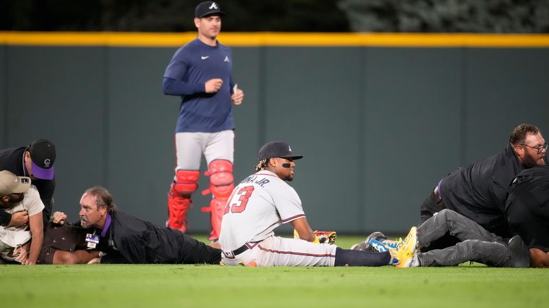 Atlanta Braves' Ronald Acuña Jr. knocked to the ground after two fans run onto Coors Field | CNN