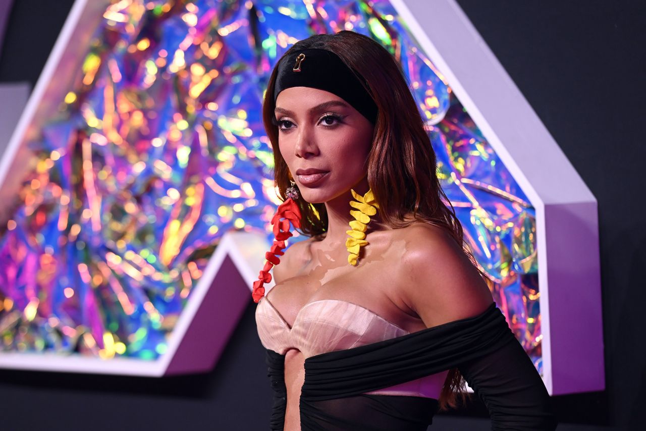 Anitta arrived in a sculptural off-the-shoulder dress, with a key-hole shaped opening at the front, from Schiaparelli's Fall-Winter Haute Couture collection. Her hand-painted rhinestone-encrusted dangle earrings brought a pop a color to the look.