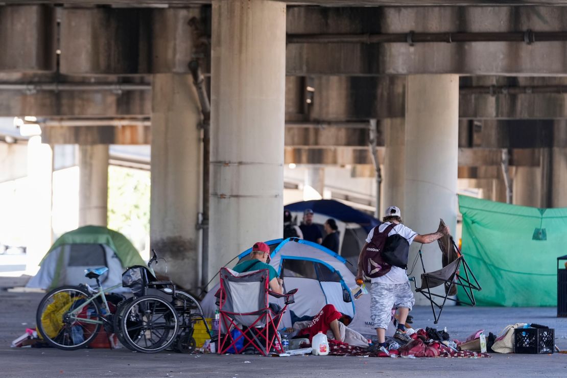People living in a homeless encampment pick up belongings after Louisiana State police gave instructions for them to move to a different pre-designated location as they perform a sweep in advance of a Taylor Swift concert in New Orleans, Wednesday, Oct. 23, 2024.