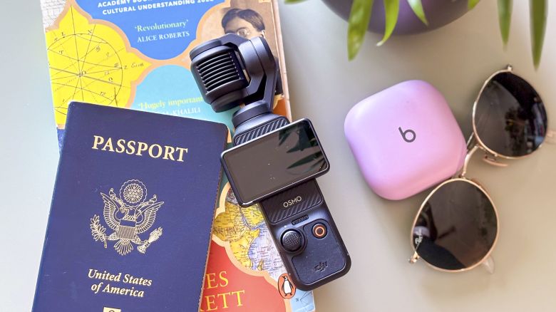 The Osmo Pocket 3 on a table with a bunch of travel accessories
