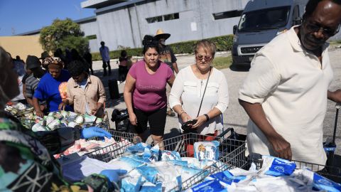 MIAMI, FLORIDA - OCTOBER 30: (L-R) Tayami Vega, Maria Ruiz, and Charles Pierre receive groceries from the Curley's House Food Bank days before the Supplemental Nutrition Assistance Program (SNAP) benefits may expire due to the Federal government shutdown on October 30, 2025 in Miami, Florida. Lavern Spicer, CEO/Founder of Curley's House Food Bank, said that "Food banks will catch hell because people will not be able to get their government benefits. Food banks will need more funding for food and all of that, due to more people turning to them for assistance." The U.S. government said it will interrupt SNAP benefits on Nov. 1st. In Miami-Dade County, nearly one in six residents receives food assistance.  (Photo by Joe Raedle/Getty Images)