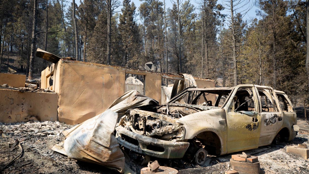 A burned car and building are seen in Cedar Creek, New Mexico, on June 18, after mass evacuations were issued due to the South Fork Fire burning near the village of Ruidoso. 