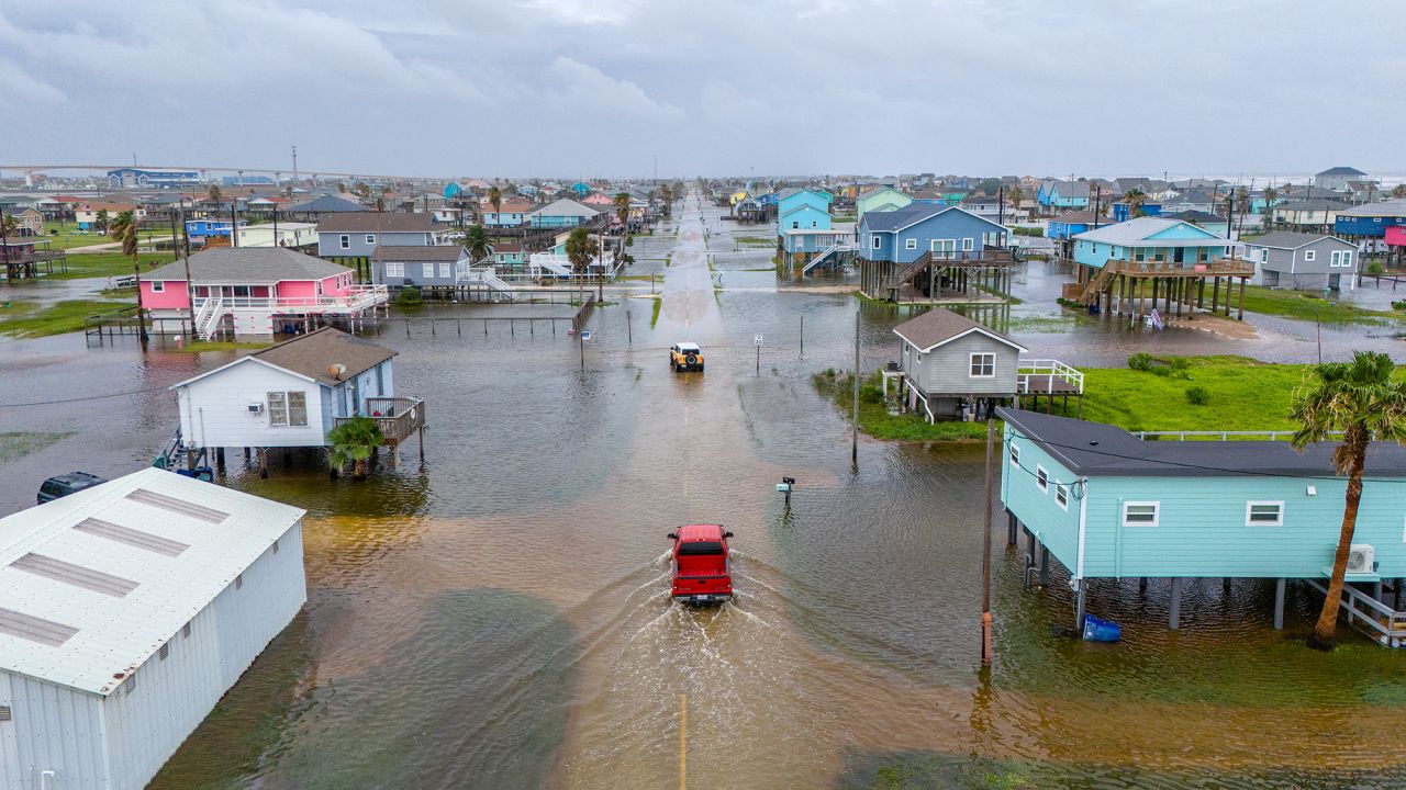 Vehicles drive through flooded neighborhoods in Surfside Beach, Texas, on June 19.