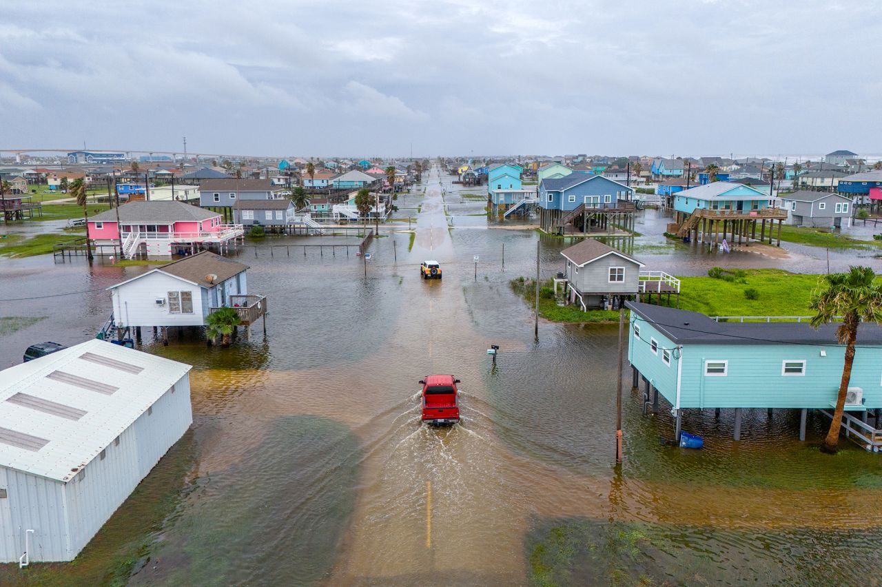 Vehicles drive through flooded neighborhoods in Surfside Beach, Texas, on June 19.