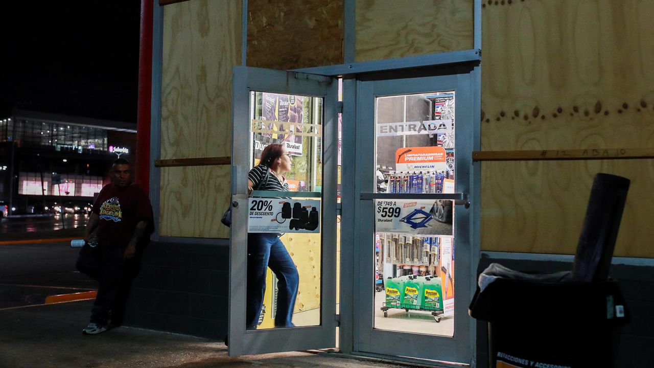 A person walks inside a store with boarded up glass panels to protect it from the impact of Tropical Storm Alberto, in Tampico, Mexico on June 19.