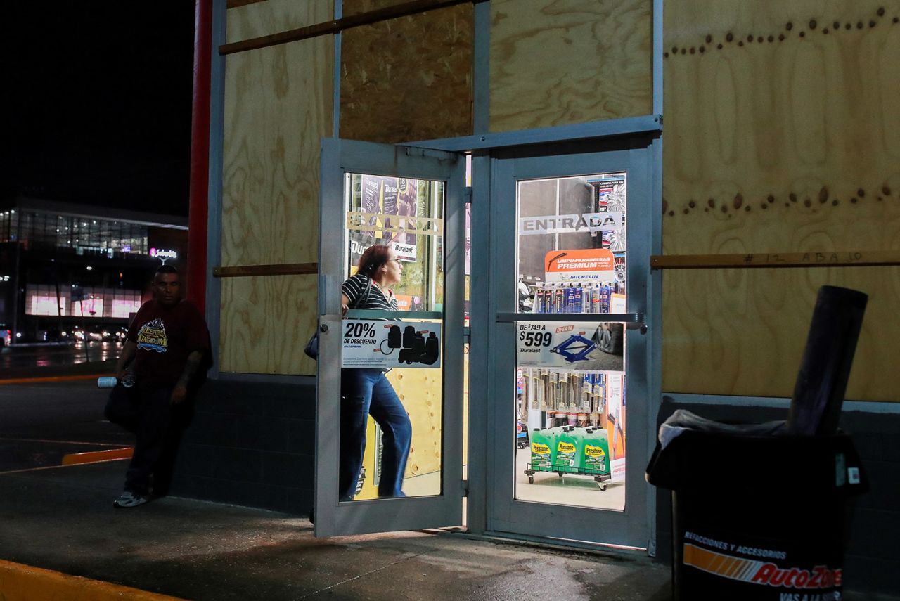 A person walks inside a store with boarded up glass panels to protect it from the impact of Tropical Storm Alberto, in Tampico, Mexico on June 19.