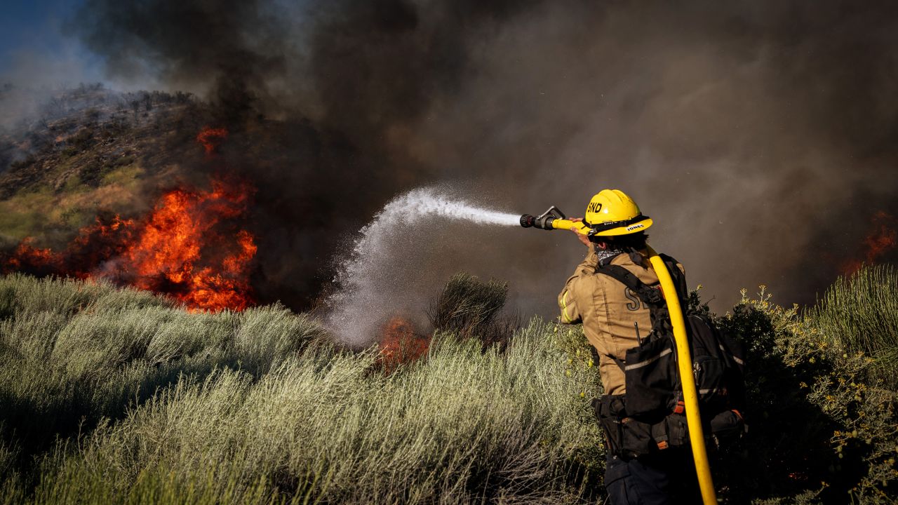 On Orwin road fire crews battle a hot spot at the Gorman Brush Fire on June 16, in Gorman, CA.