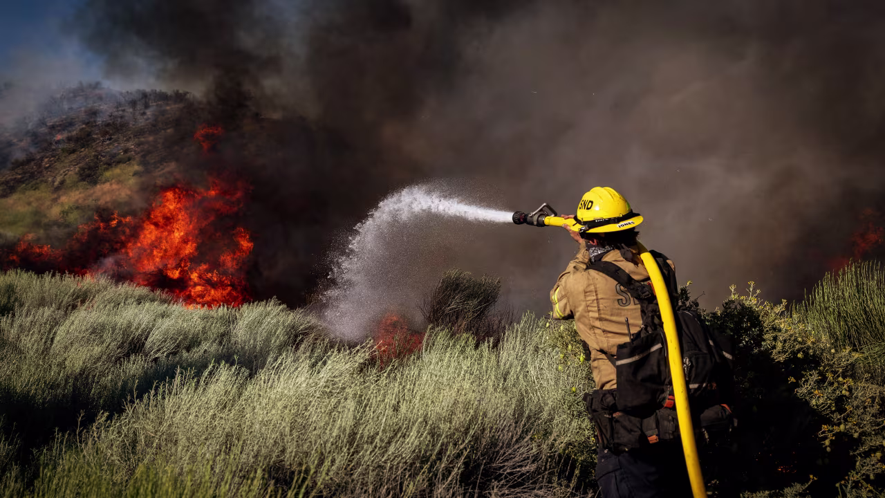 On Orwin road fire crews battle a hot spot at the Gorman Brush Fire on June 16, in Gorman, CA.