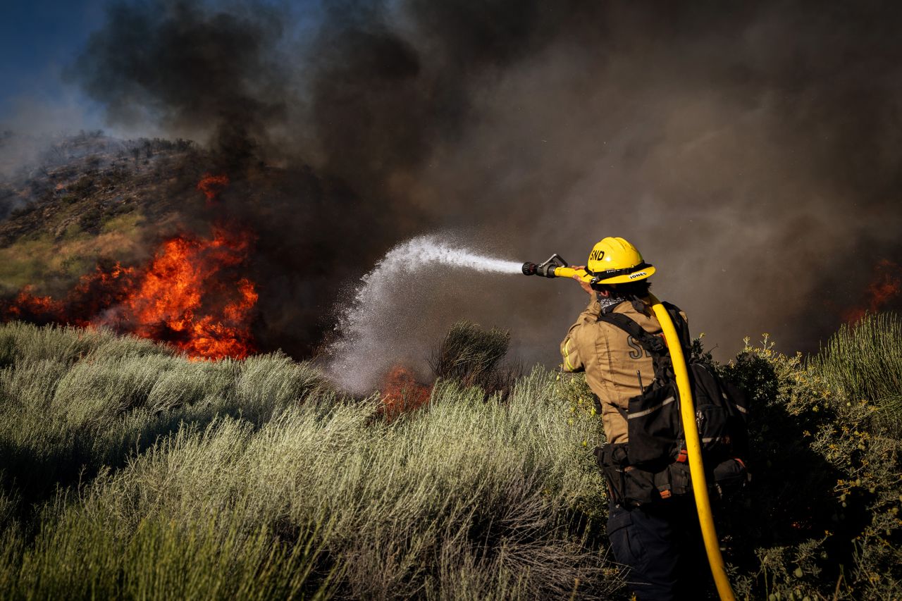 On Orwin road fire crews battle a hot spot at the Gorman Brush Fire on June 16, in Gorman, CA.