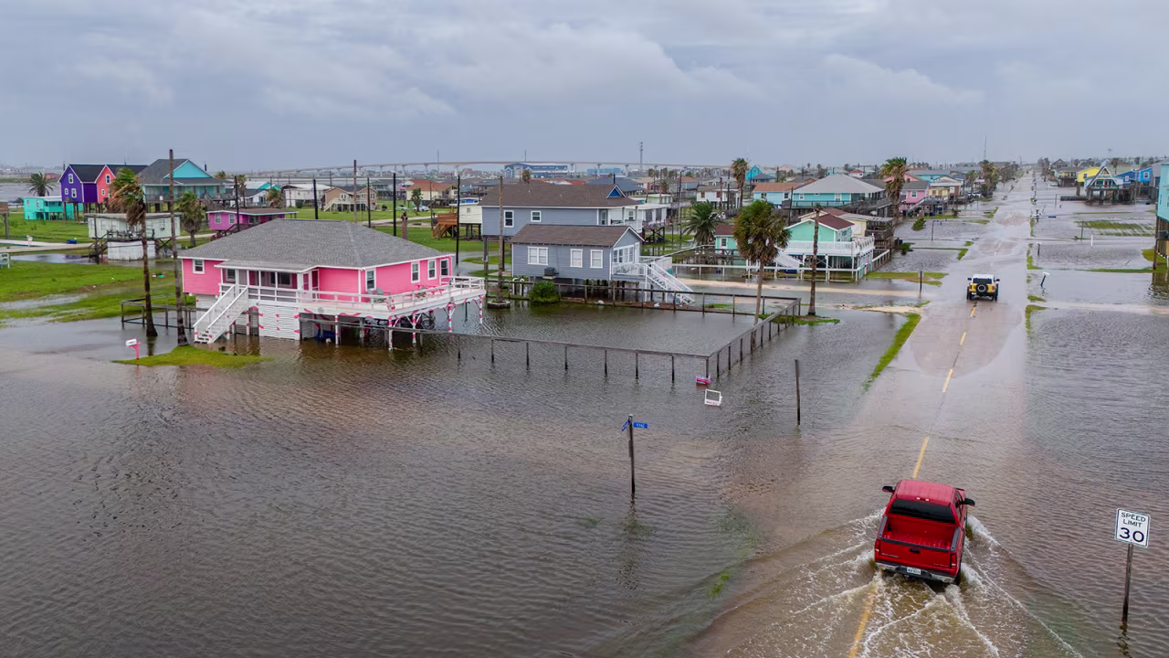 Vehicles drive through flooded neighborhoods in Surfside Beach, Texas on June 19.