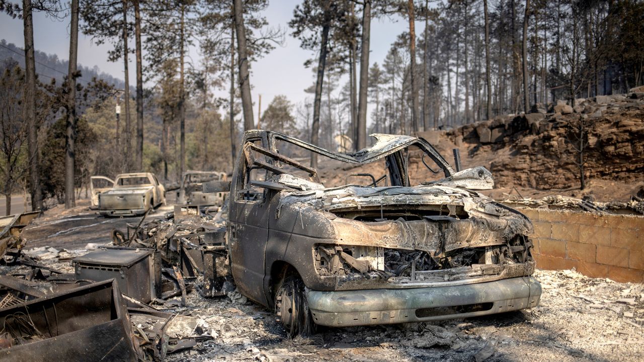 Skeletons of vehicles sit in front of residences in the aftermath of the South Fork fire in Alto, New Mexico, on June 19.