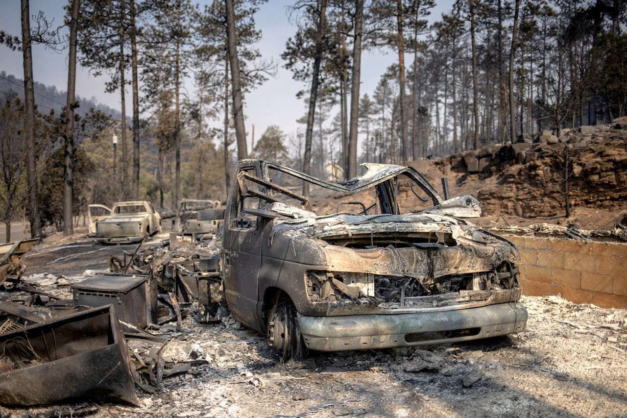 Skeletons of vehicles sit in front of residences in the aftermath of the South Fork fire in Alto, New Mexico, on June 19.