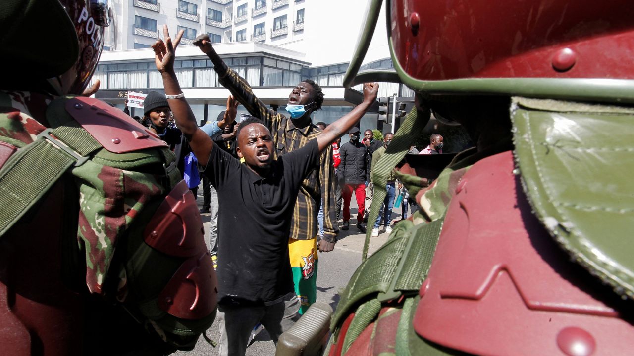 Demonstrators react as police stand guard during a demonstration against Kenya's proposed finance bill in Nairobi, Kenya, on June 25.