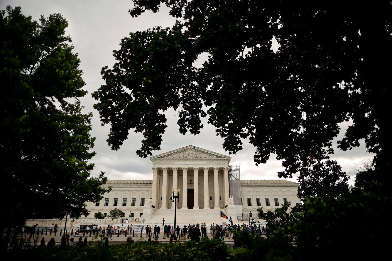 Demonstrators, members of the media, and bystanders gather outside the Supreme Court on July 1 in Washington, DC.