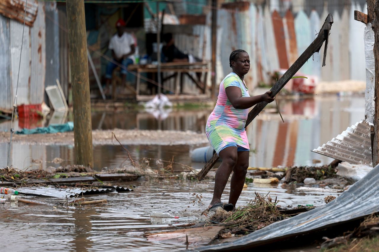Simone Francis gathers items from her home that were blown away as Hurricane Beryl passed through the area on Thursday in Old Harbor, Jamaica. 