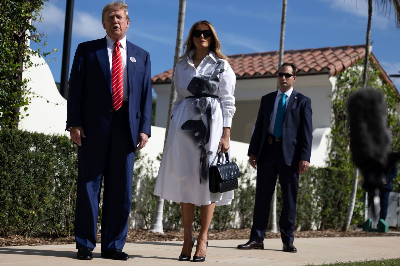 Former President Donald Trump and former first lady Melania Trump stand together as he speaks with the media after voting at a polling station setup in the Morton and Barbara Mandel Recreation Center on March 19, 2024, in Palm Beach, Florida. 