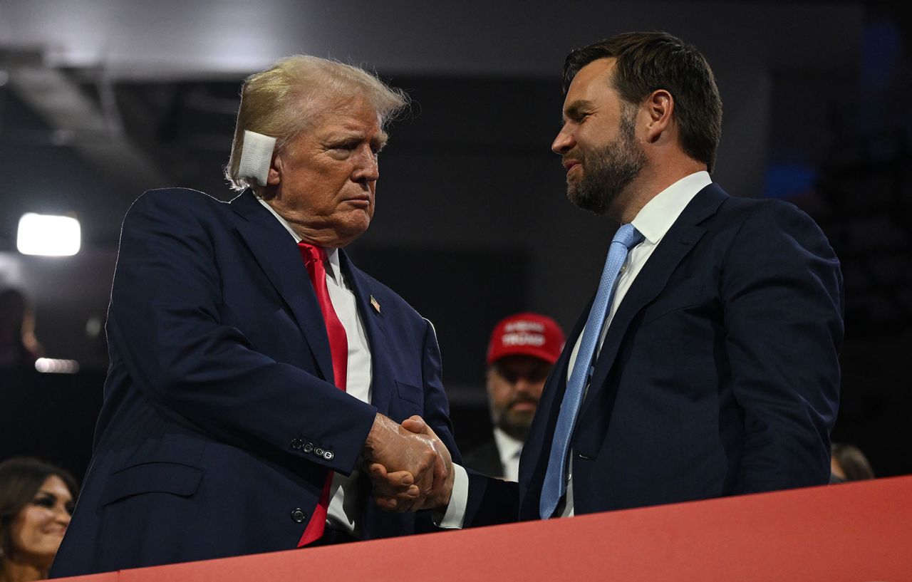 Former President Donald Trump and his new running mate JD Vance shake hands on the opening night of the convention on Monday, July 15.