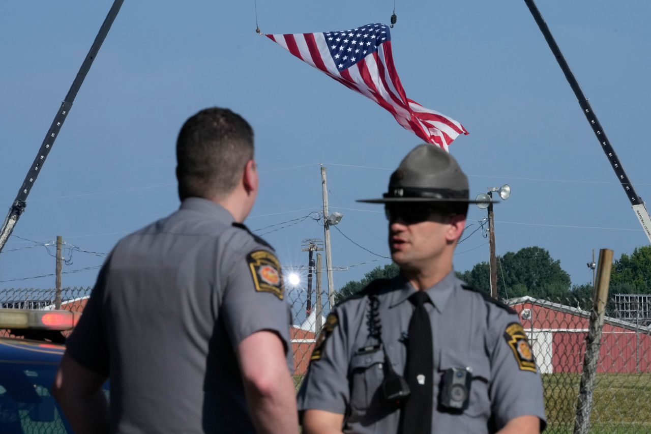 Police officers stand at a road leading to the site of the Trump rally in Butler, Pennsylvania, on July 14, 2024.