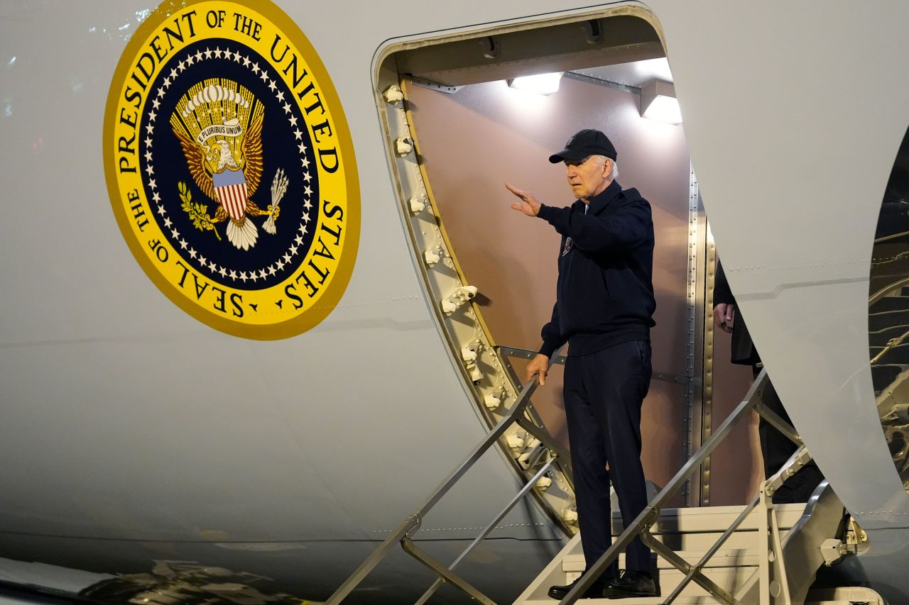 President Joe Biden waves as he walks down the steps of Air Force One at Dover Air Force Base in Delaware on Wednesday night.