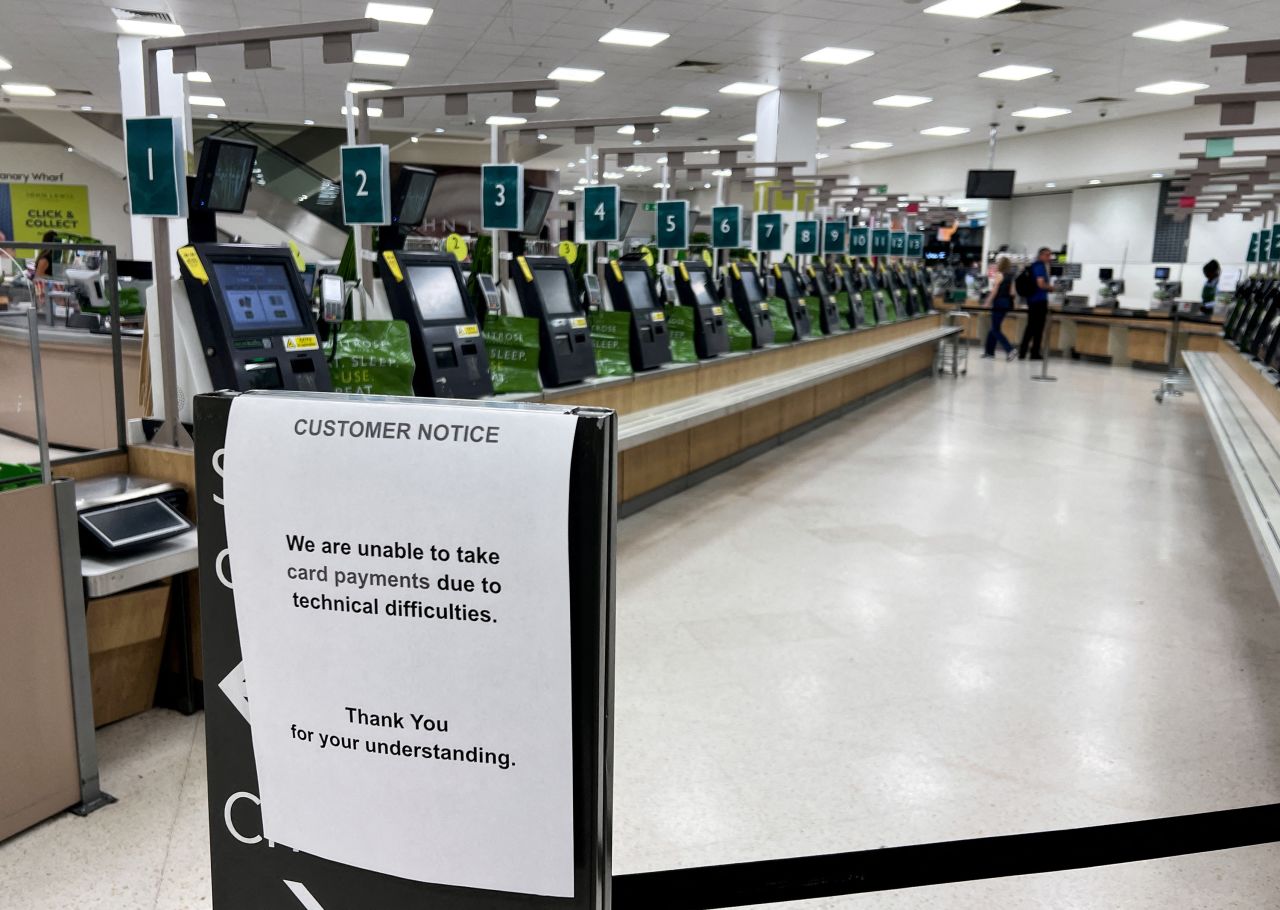 A notice informs customers that they cannot pay by card during a technology outage at a Waitrose supermarket in London on July 19.