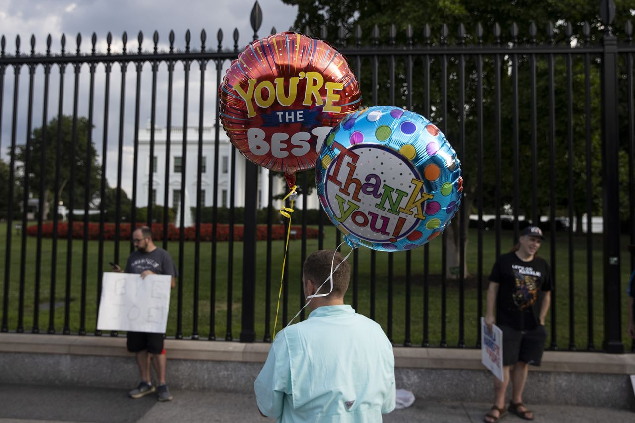 A person holds balloons outside the White House after US President Joe Biden announced he was dropping out of the election on July 21.