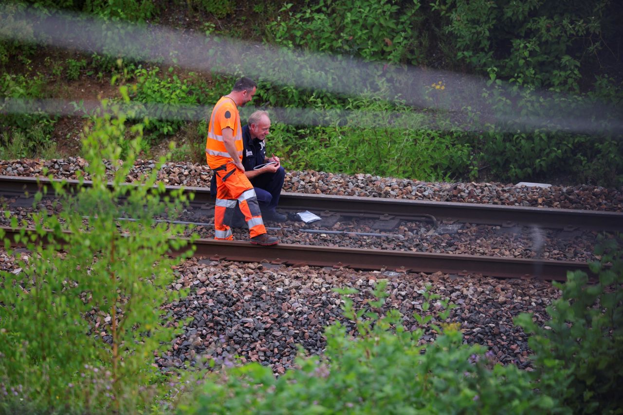 A SNCF railway staff member and a police officer work at a site where vandals targeted France's high-speed train network in Croisilles, northern France, on Friday, July 26. 