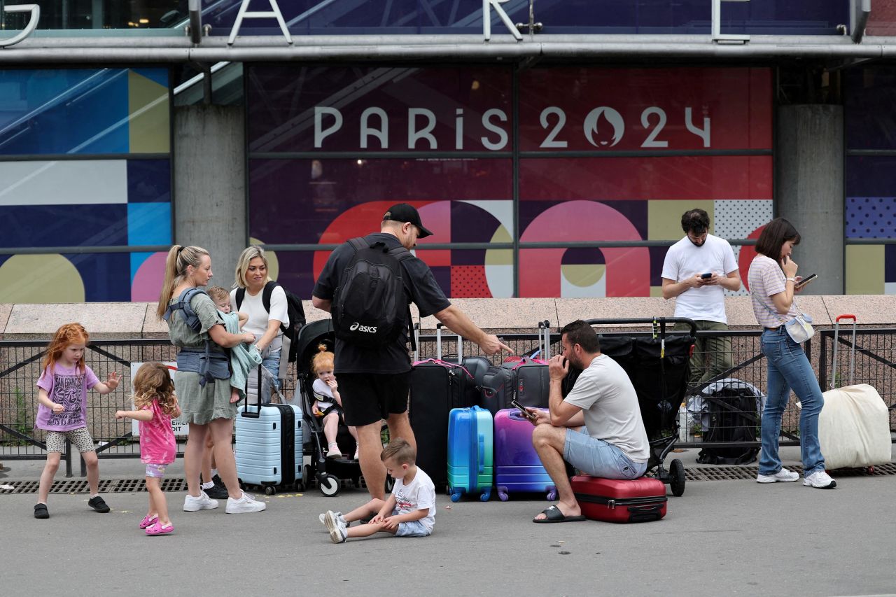Des voyageurs en provenance de Sydney, en Australie, attendent devant la gare Montparnasse à Paris alors qu'ils tentent de trouver d'autres trains après que leur voyage ait été affecté par des perturbations ferroviaires.