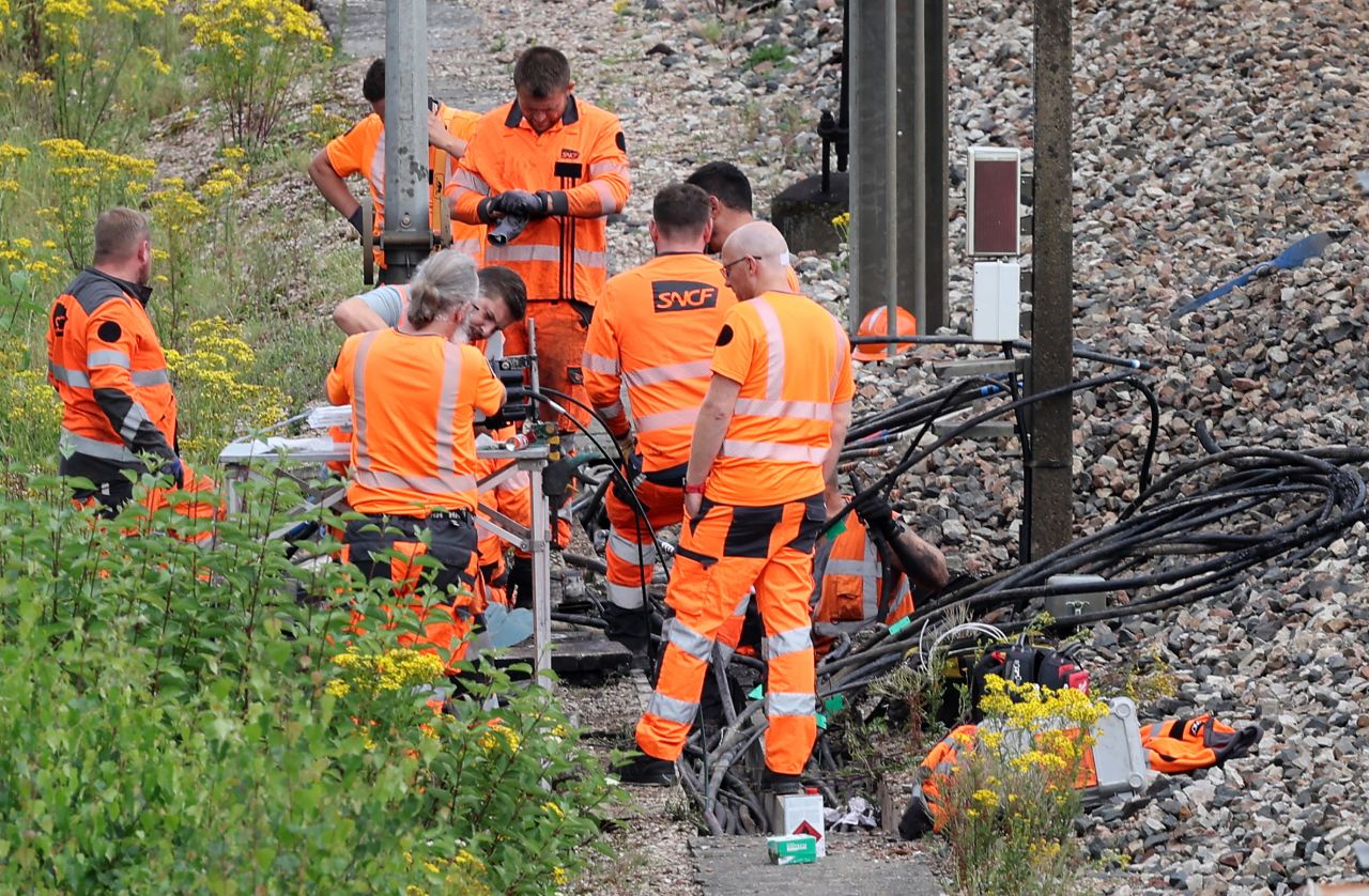 SNCF employees inspect the scene of a suspected attack on France's high speed railway network at Croiselles, northern France, on July 26.