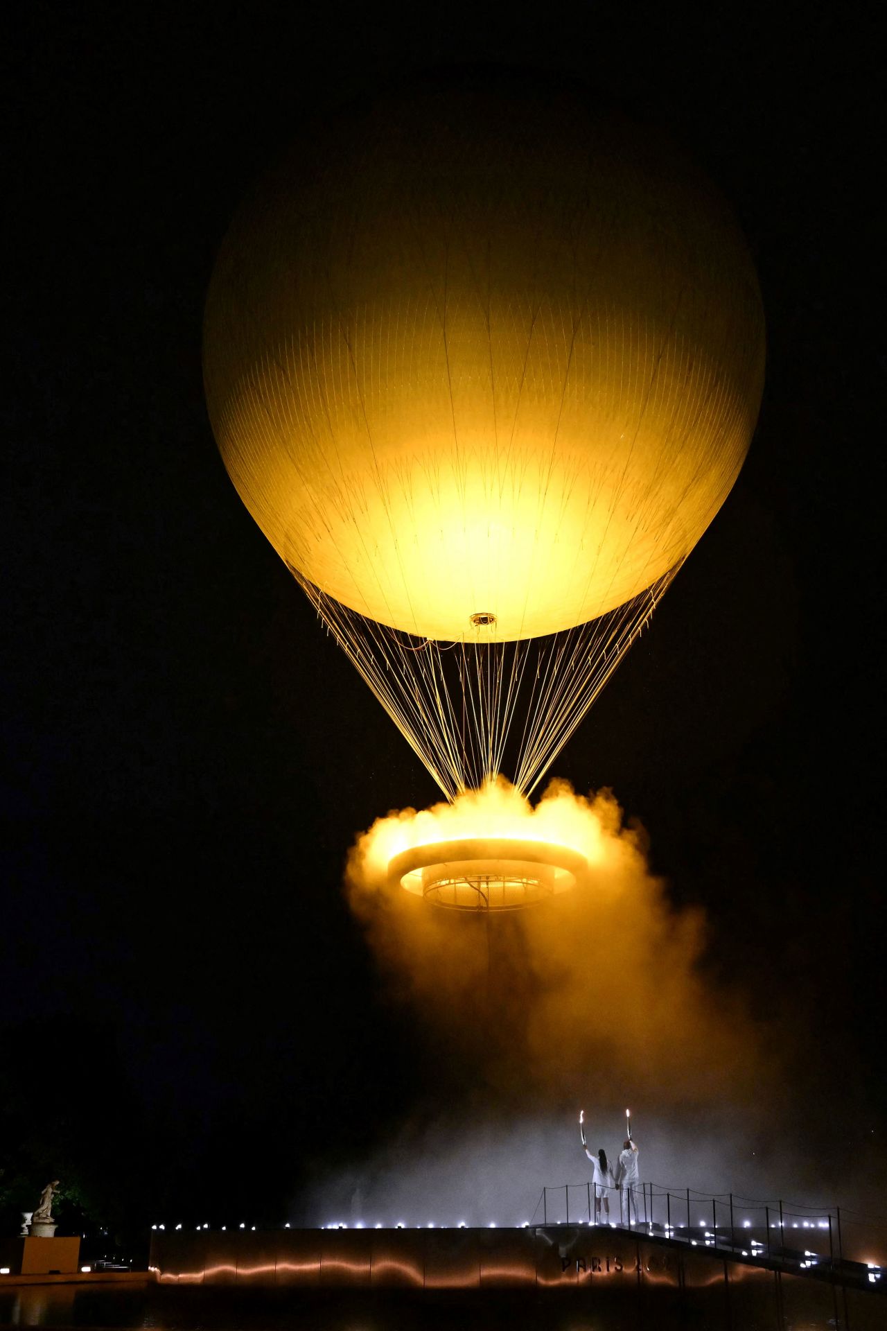 El pebetero que porta la antorcha olímpica se eleva unido al globo en el Jardín de las Tullerías. 