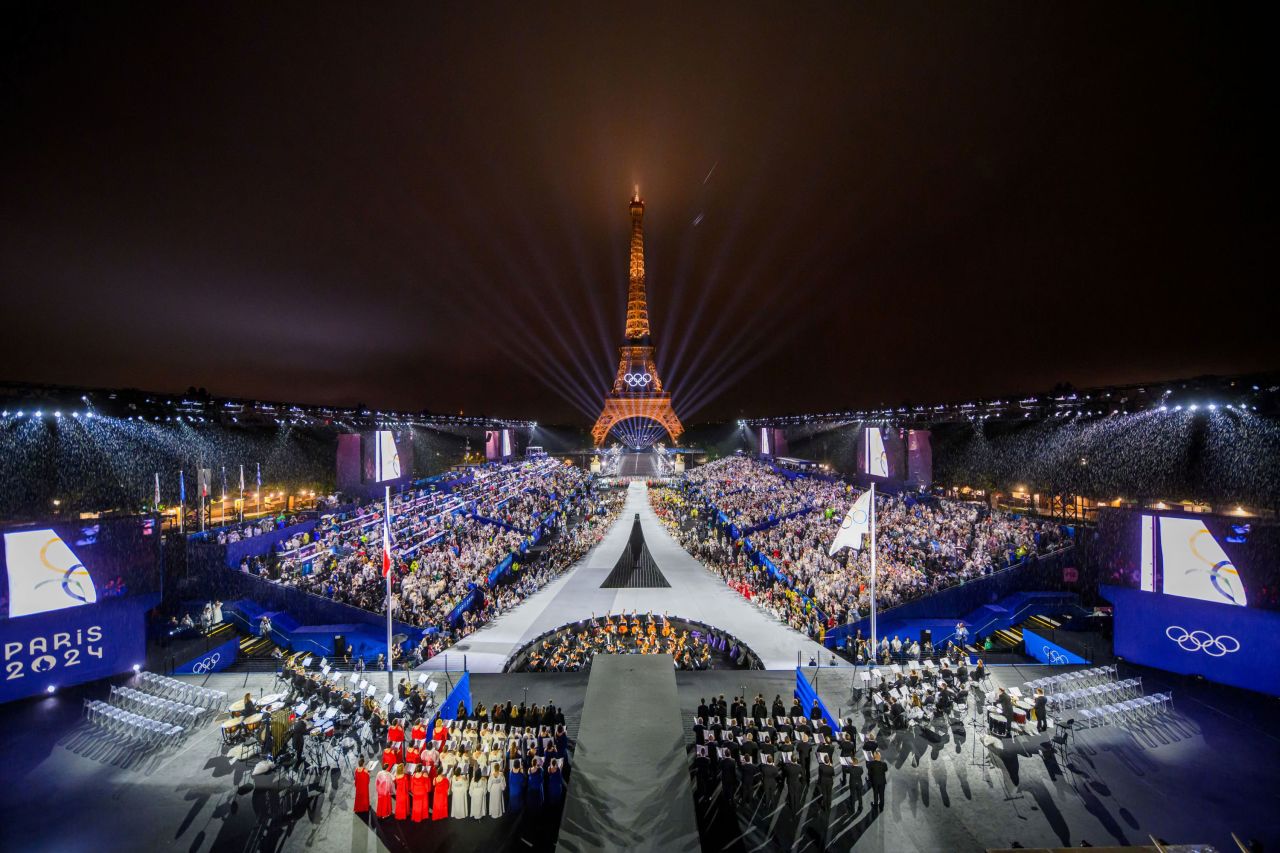 La Torre Eiffel brilla al fondo mientras se iza la bandera olímpica durante la ceremonia de apertura en París el 26 de julio. 