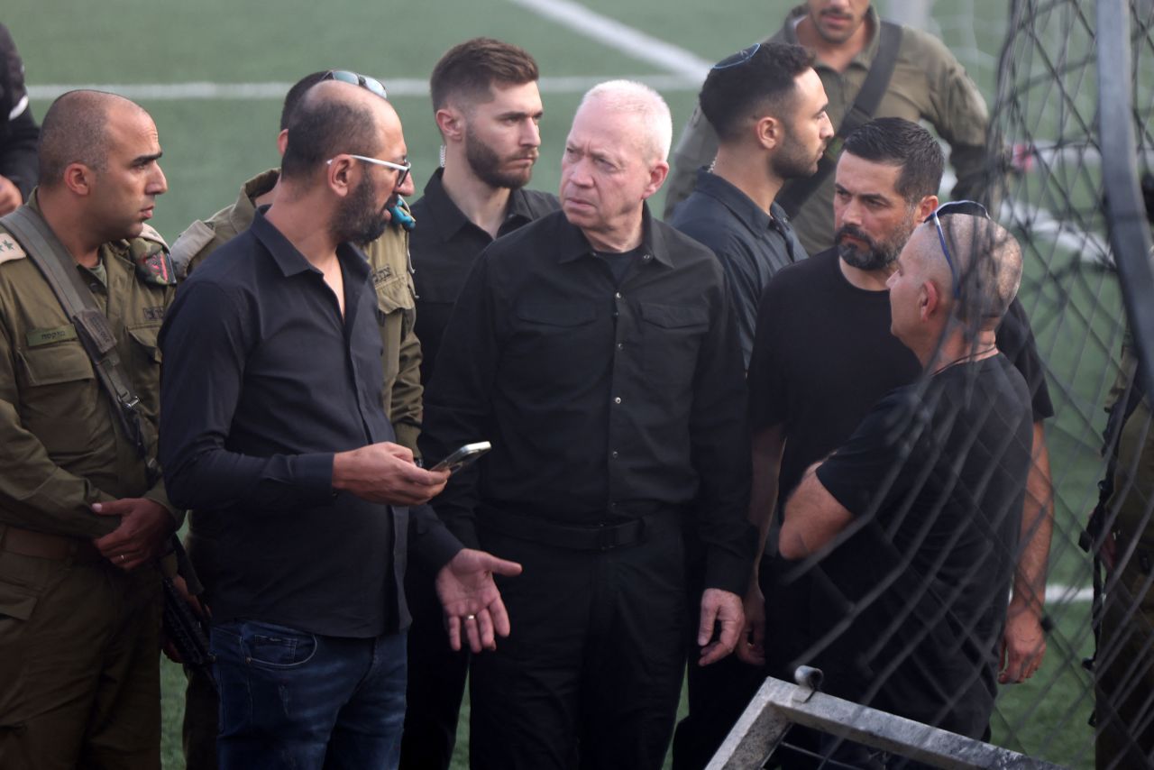 Israeli Defense Minister Yoav Gallant, center, visits the site where a Hezbollah strike fell in Majdal Shams village on Sunday.