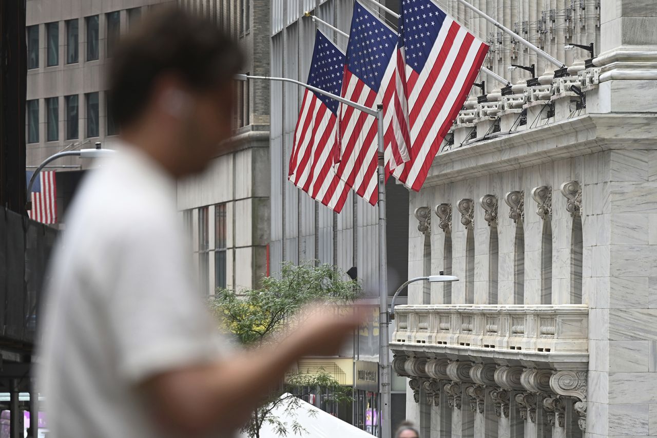 People walk past the New York Stock Exchange on July 24.