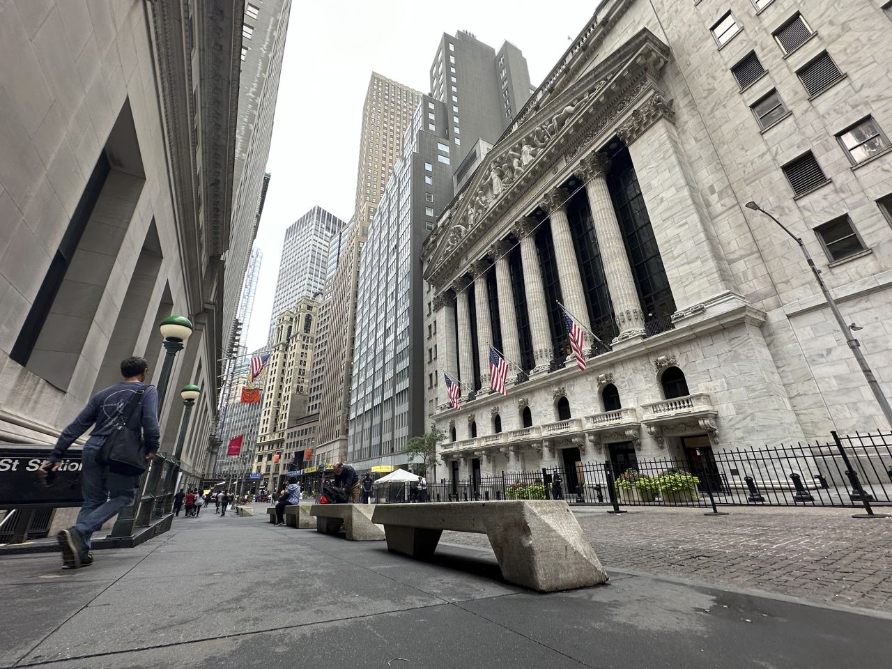 People pass the New York Stock Exchange on Tuesday, July 30.