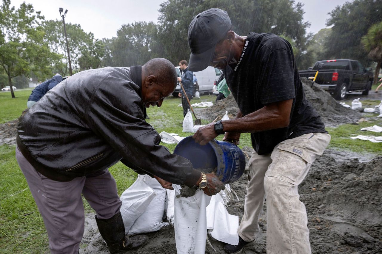 Hershey Stepherson, left, and Bryan Burc, right, fill a sandbag while preparing for Hurricane Debby on Monday in Savannah, Georgia. 