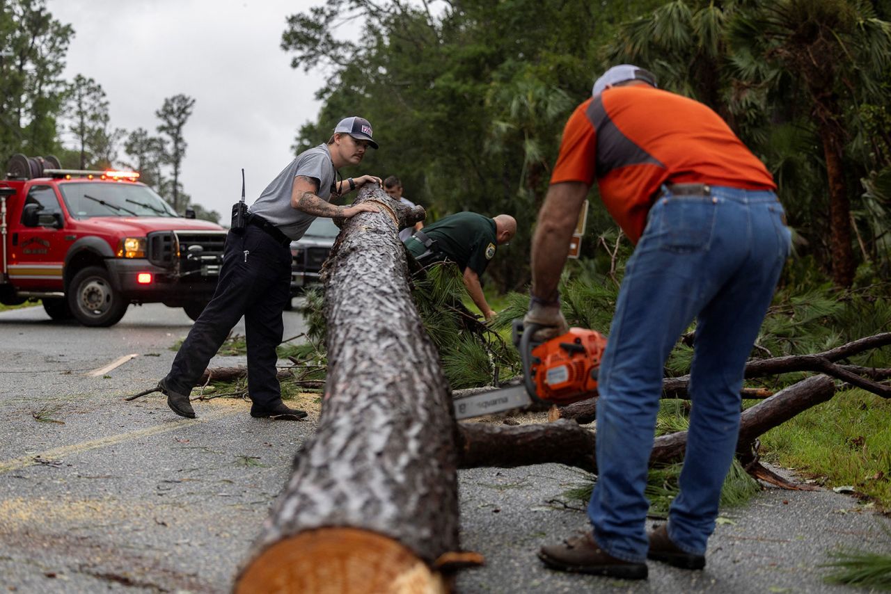 Taylor County firefighters remove a fallen tree from a road as Debby passes through the area in Keaton Beach, Florida, on August 5.