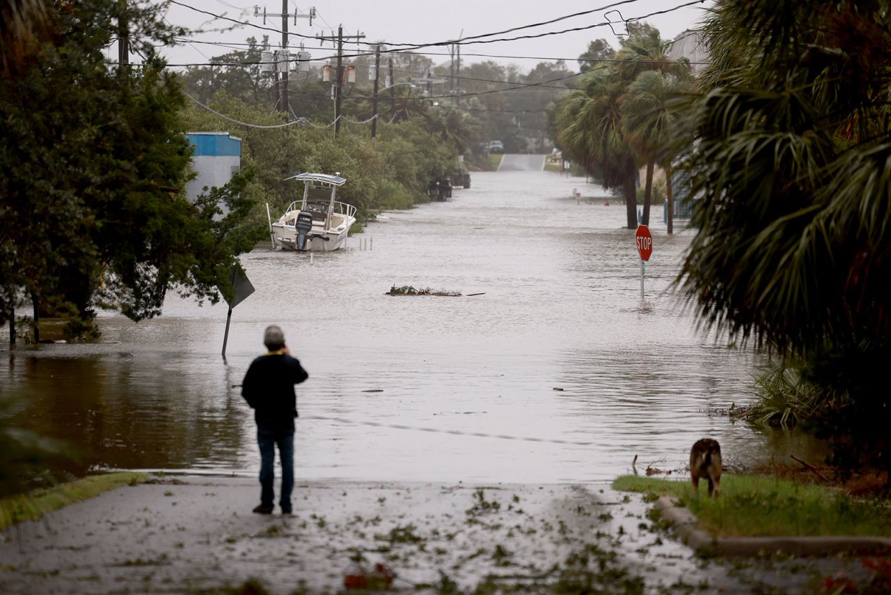 A person looks on at a flooded street caused by the rain and storm surge from Hurricane Debby on August 5 in Cedar Key, Florida. 