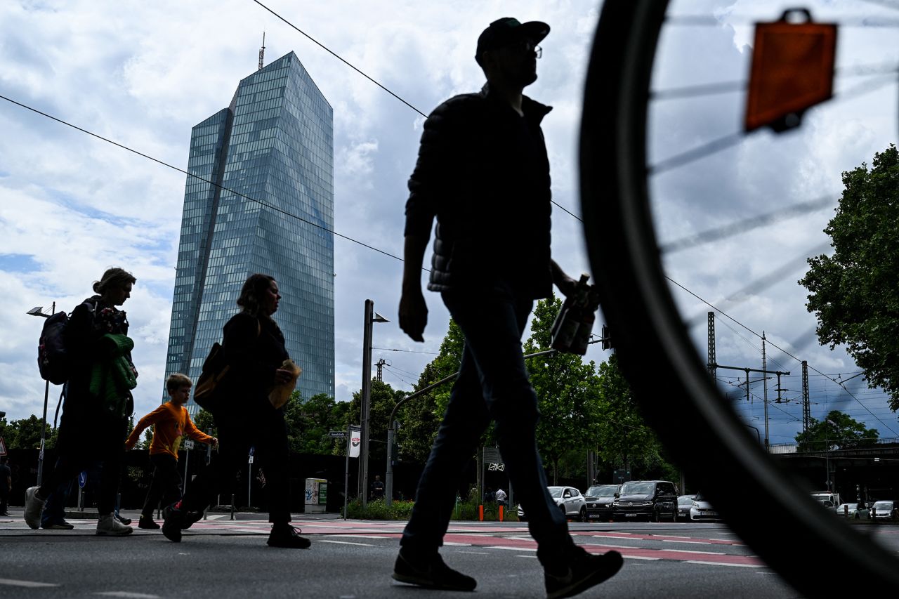 People cross a street in front the headquarters building of the European Central Bank in Frankfurt am Main, western Germany, on June 5.