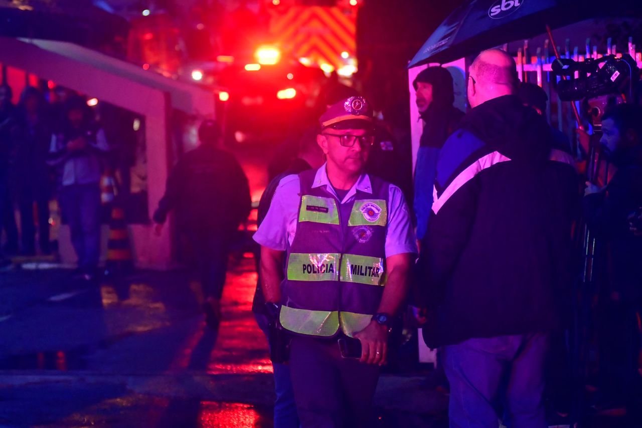 A police member stands guard near the scene of the plane crash on Friday, August 9, in Vinhedo, Brazil. 