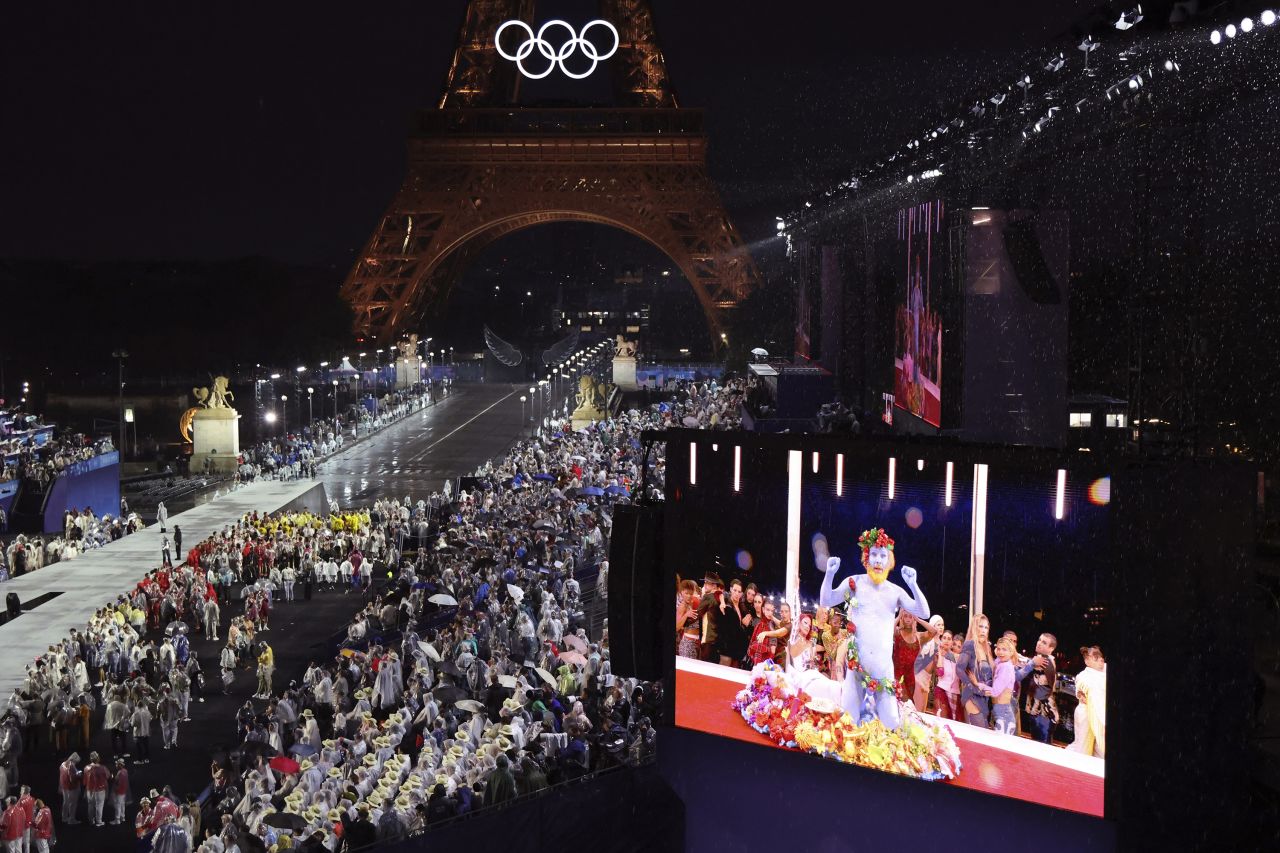 Delegations arrive at the Trocadéro during the opening ceremony of the Olympic Games, as French singer Philippe Katerine is seen performing on a screen, in Paris on July 26.