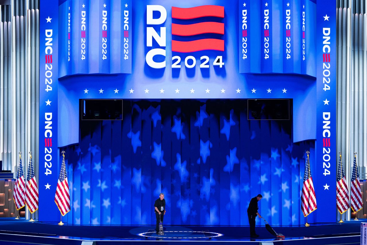 Stagehands vacuum the stage inside the United Center before the start of day two of the 2024 Democratic National Convention in Chicago on Tuesday, August 20.