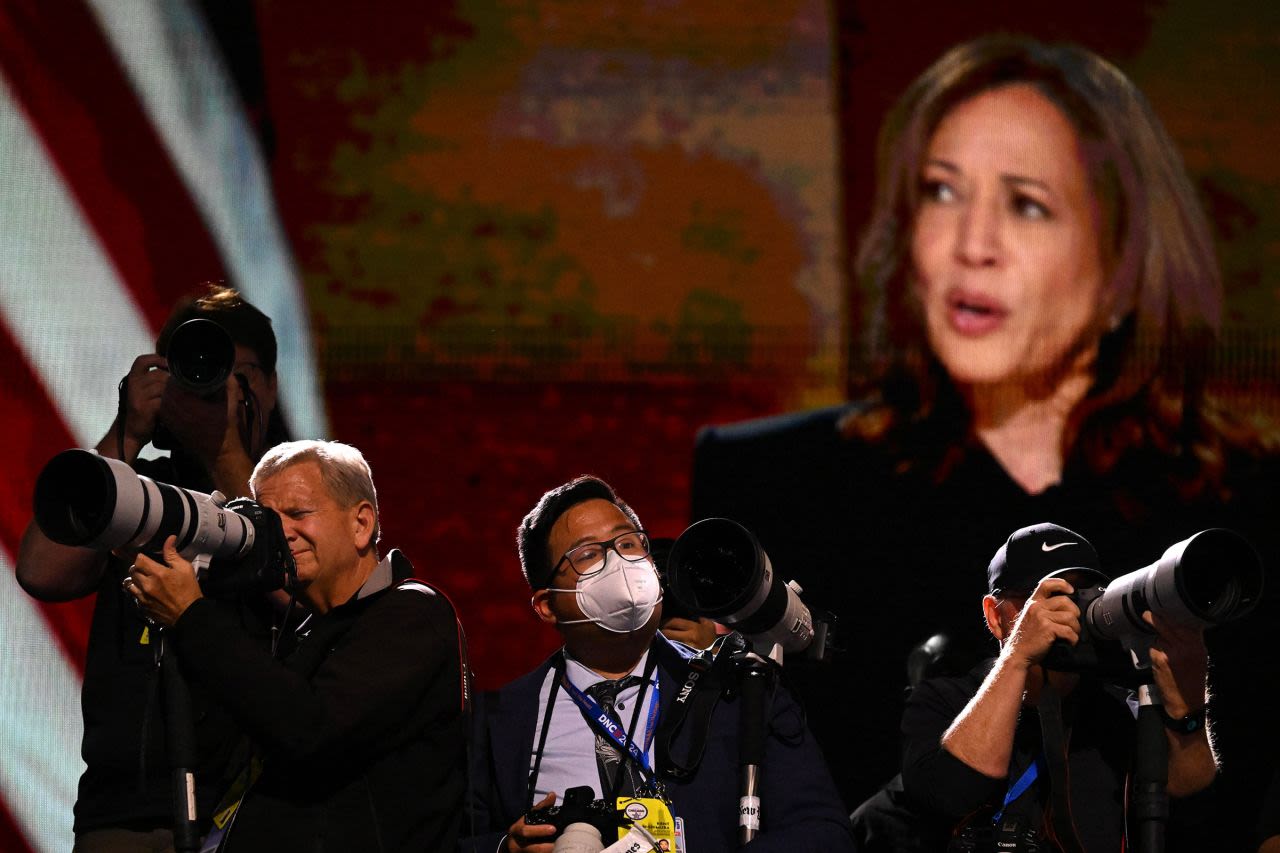 Photographers work during Harris' speech on Thursday.  