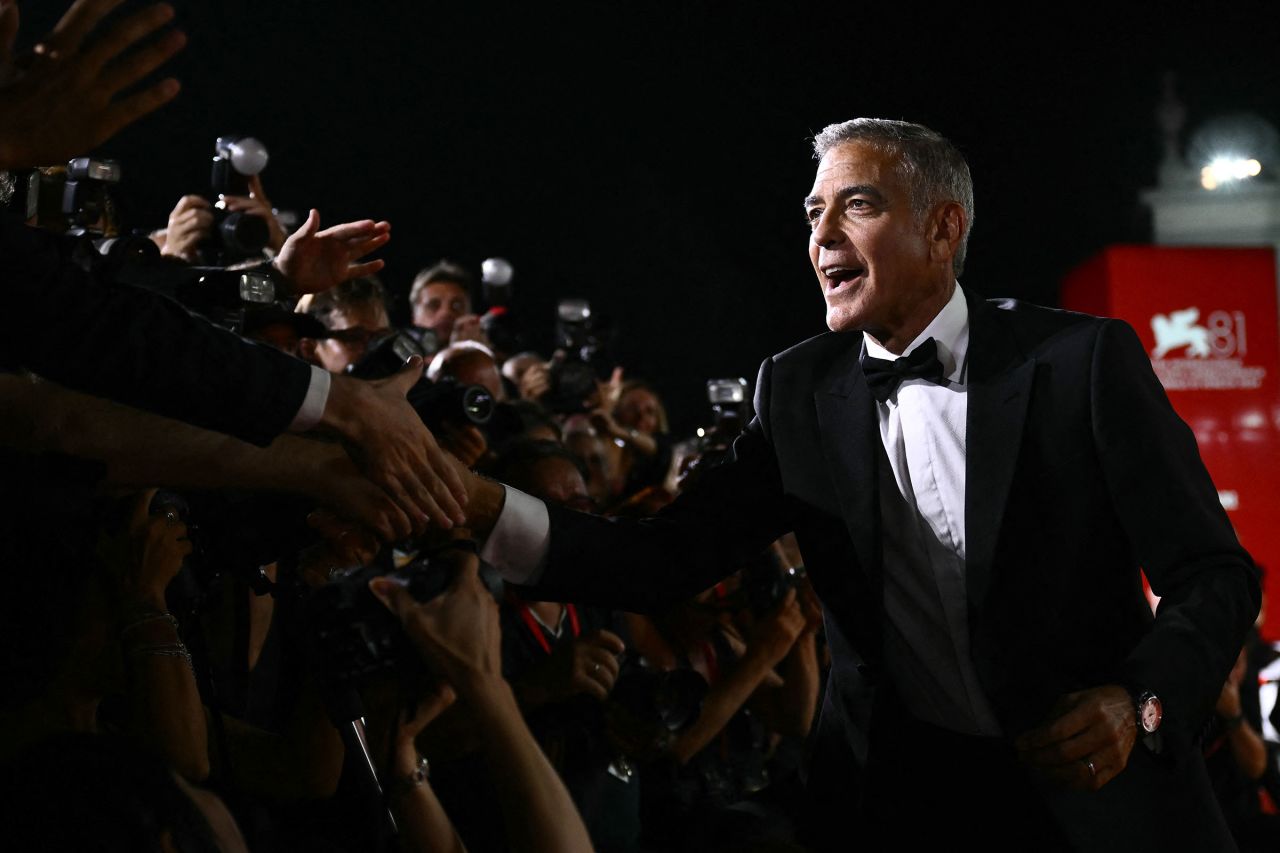 Actor George Clooney greets photographers as he attends the red carpet of the movie "Wolfs" presented out of competition during the 81st International Venice Film Festival at Venice Lido, on September 1.