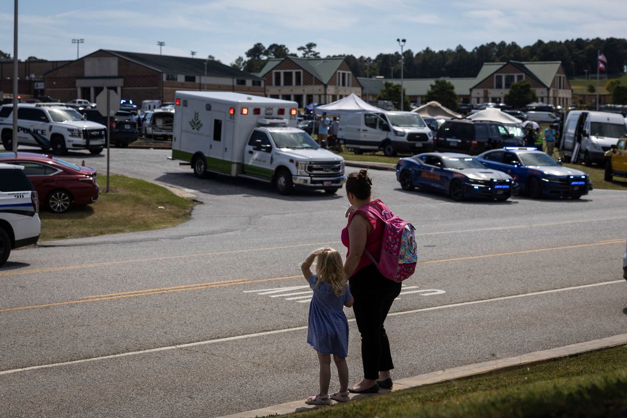 A young girl and her mother watch as law enforcement and first responders surround Apalachee High School in Winder on Wednesday.