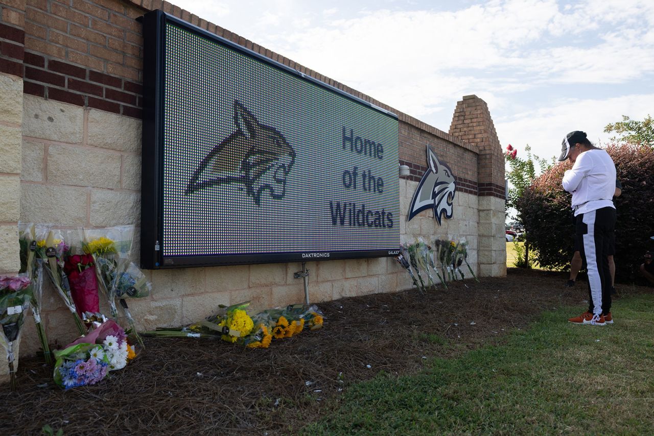 Chiman Douglas prays in front of the school sign outside of Apalachee High School on September 5 in Winder, Georgia. 