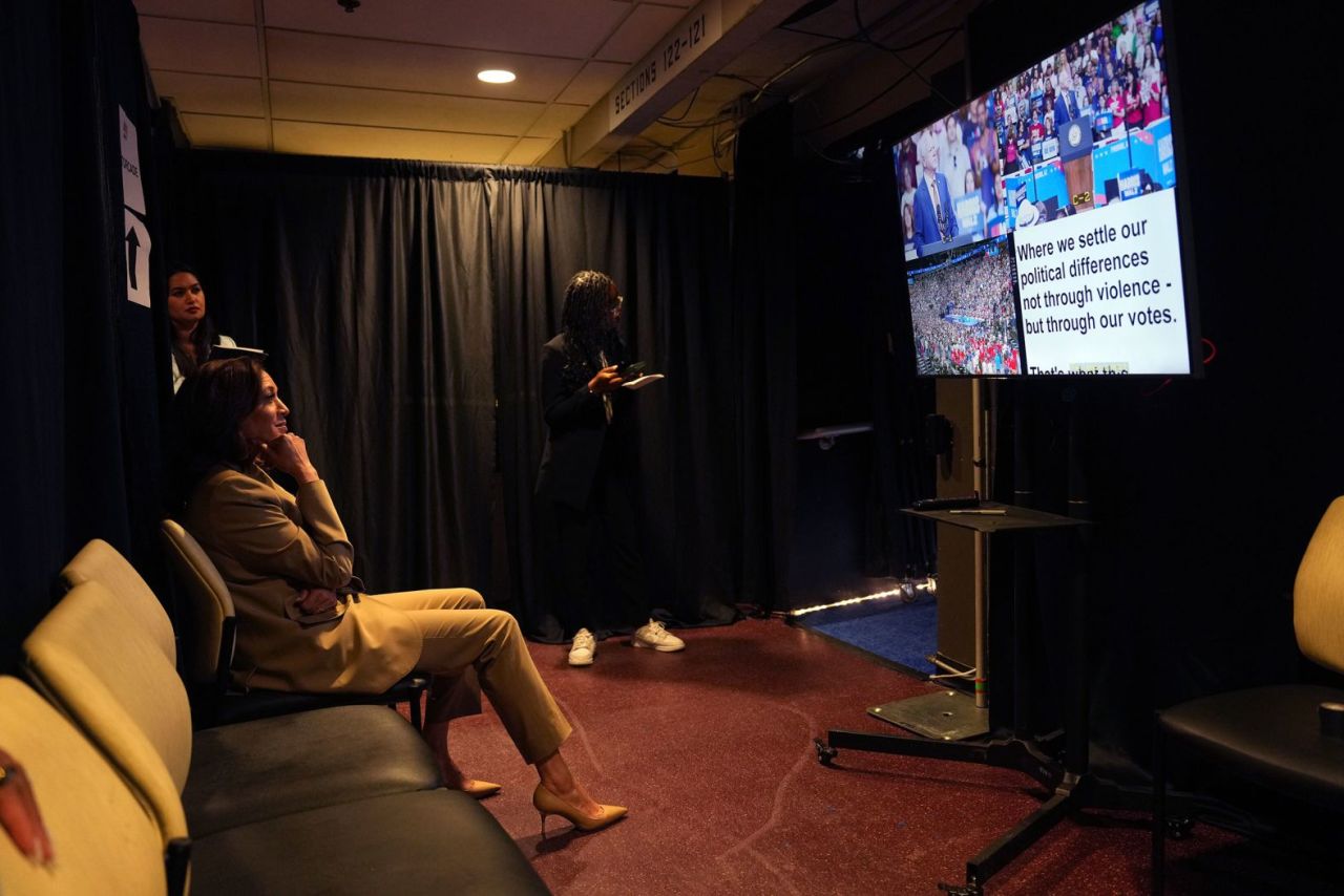 Harris watches Walz speak as she sits backstage at their rally in Glendale, Arizona, on August 9. 