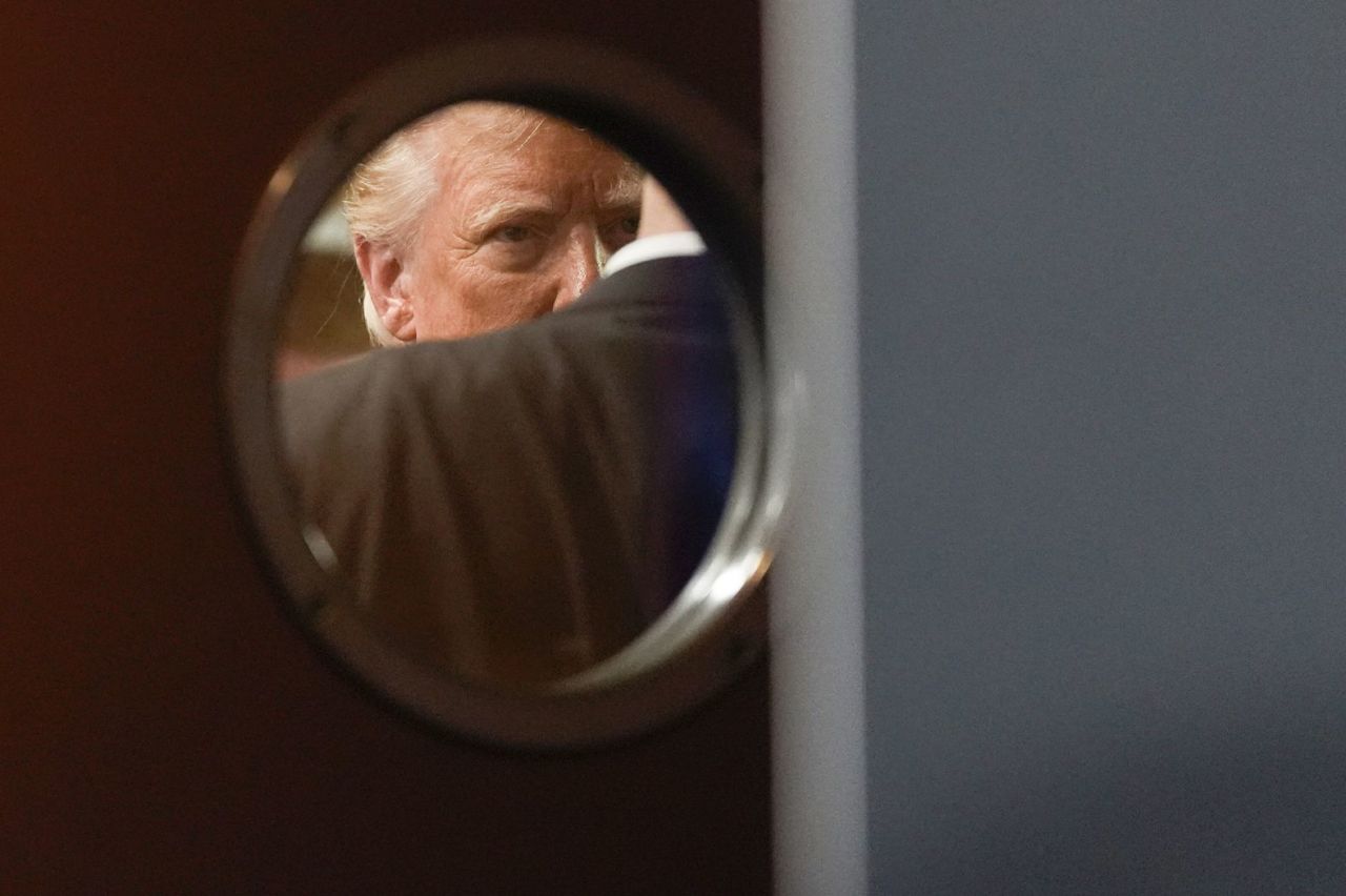 Trump is seen through a door window before speaking at a campaign event in Las Vegas on August 23. 