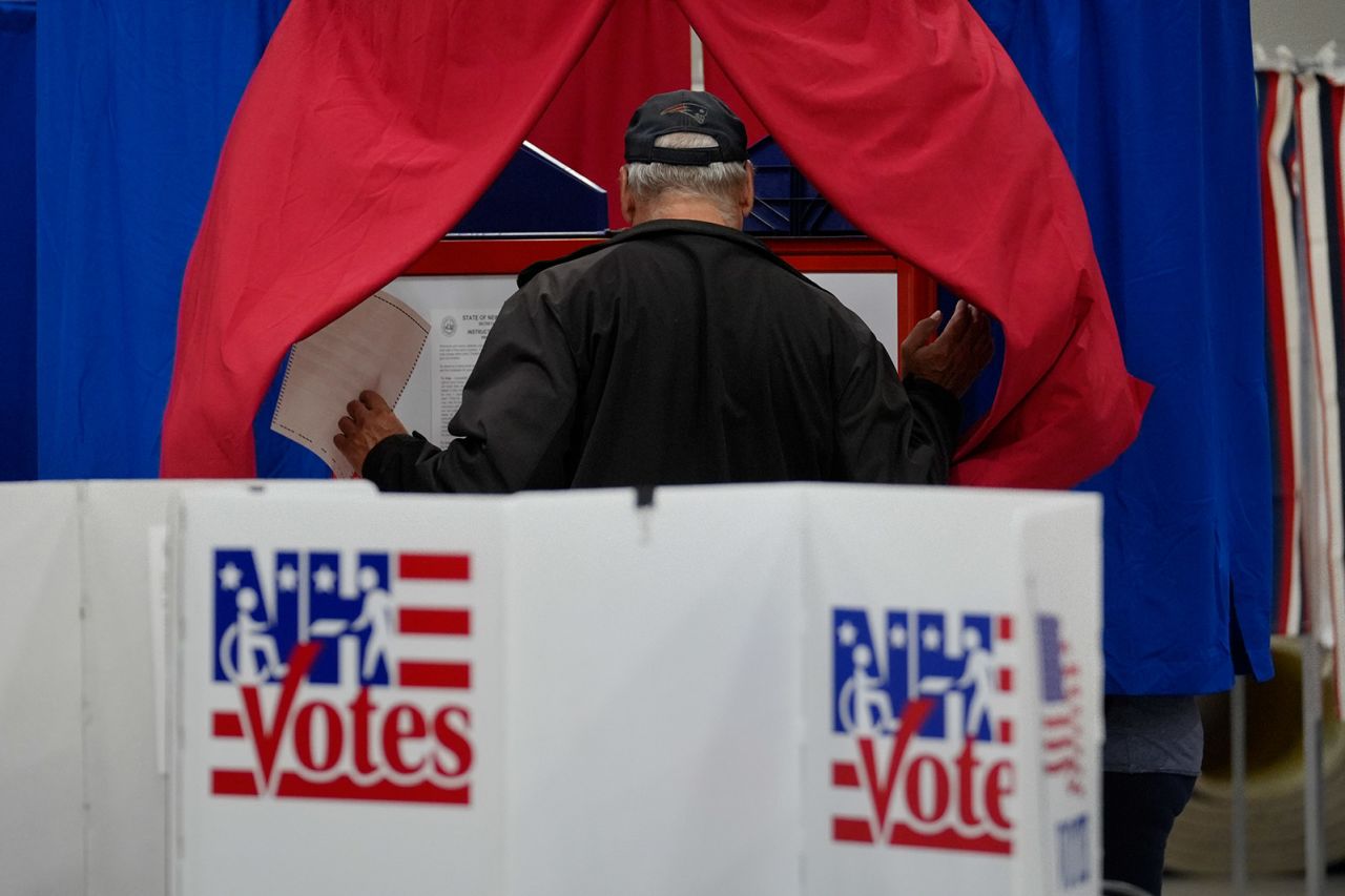 A voter enters a booth fill out a ballot in a primary election to pick candidates for governor, the US House, and the state Legislature, in Nashua, New Hampshire on September 10. 