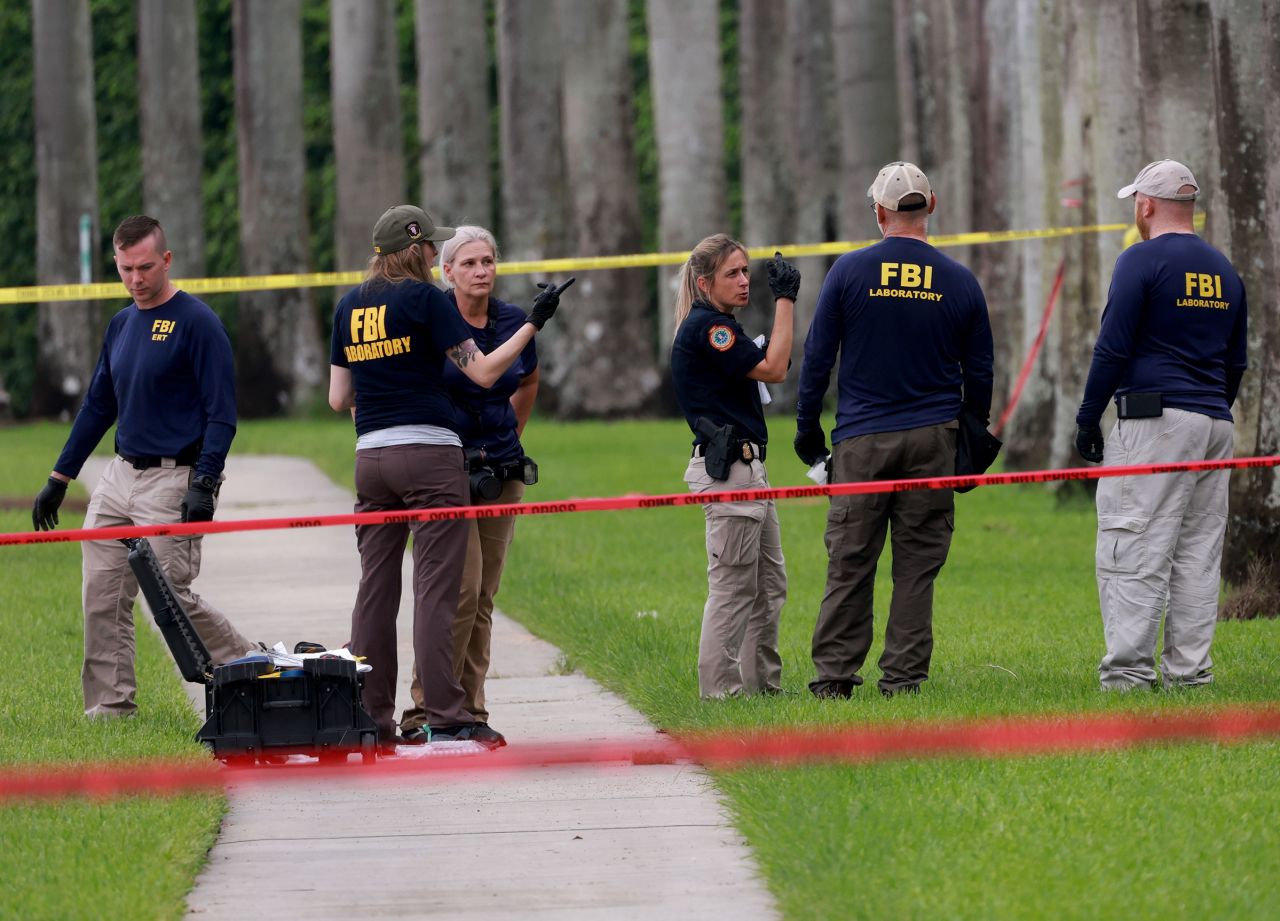 Law enforcement personnel continue to investigate the area where the Secret Service discovered a would-be assassin of former President Donald Trump at the Trump International Golf Club on September 17, in West Palm Beach, Florida. 