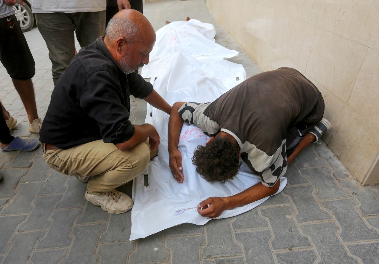 Relatives of the deceased mourn by their shrouded bodies after the victims of an Israeli attack are brought to Al Awda Hospital in Jabalia, Gaza, on September 20.