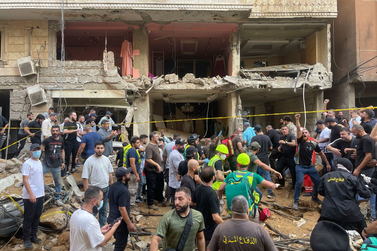 People gather near a damaged building at the scene of an Israeli missile strike in the southern suburbs of Beirut, Lebanon, on Friday.